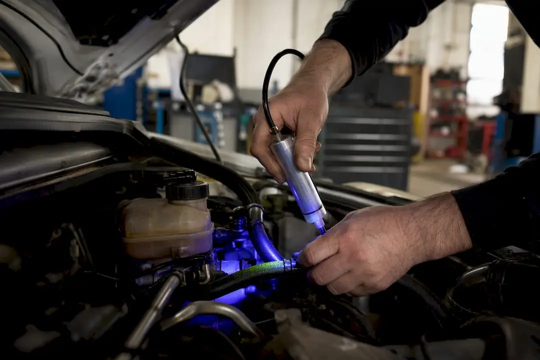 Mechanic applying UV dye leak test on steering hose