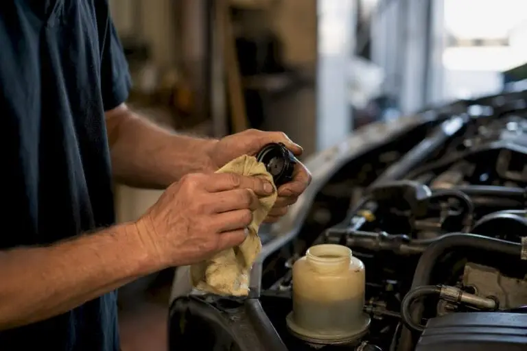 Mechanic checking power steering fluid reservoir