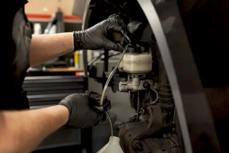 Technician bleeding brake fluid lines