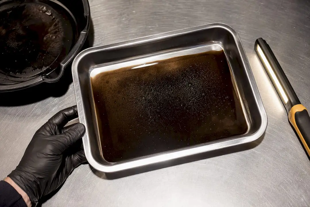 Technician examining drained transfer case fluid