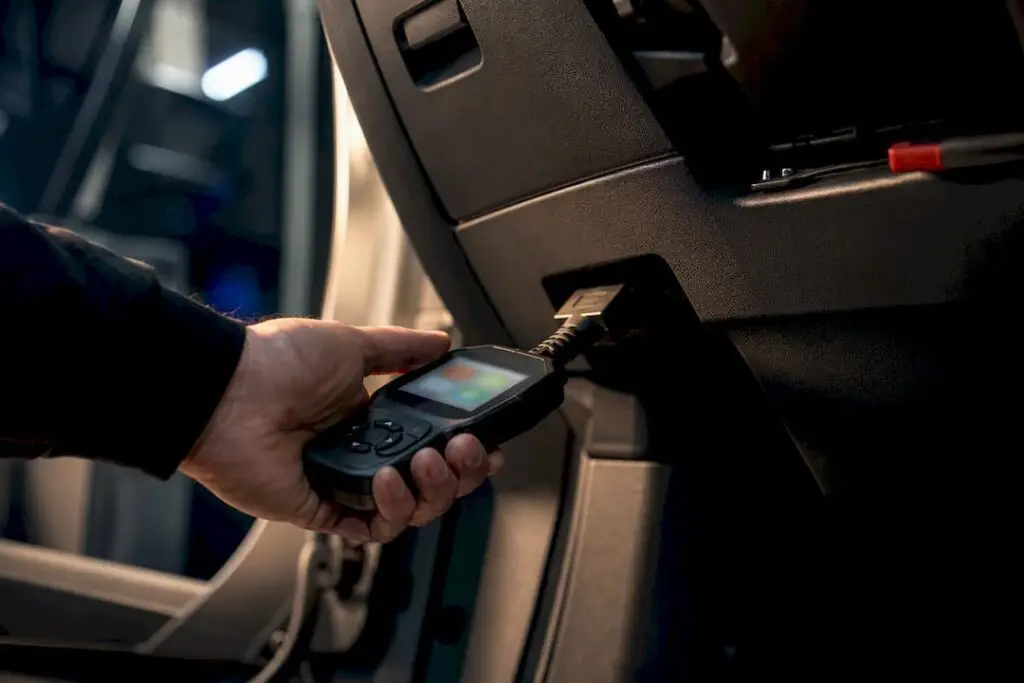 Technician connecting scanner to OBD port