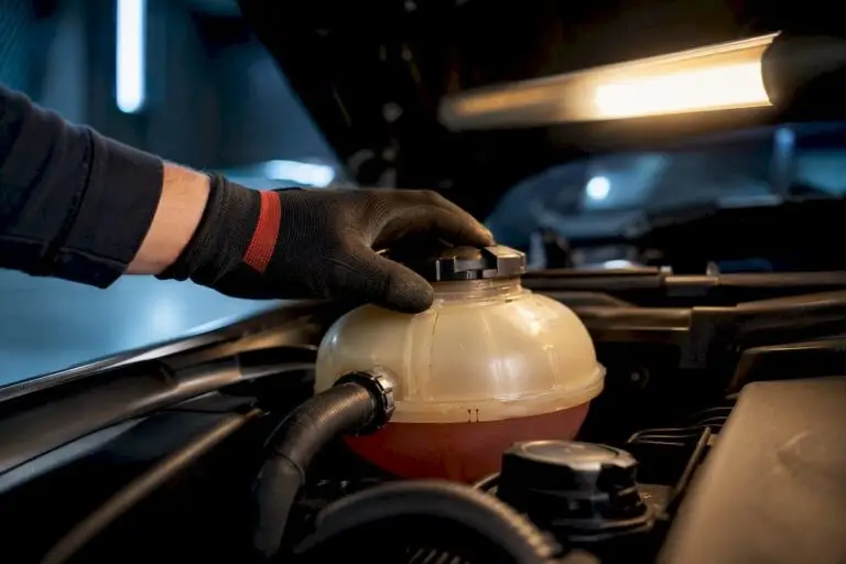 Technician inspecting a coolant expansion tank