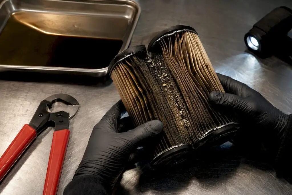Technician examining a cut-open engine oil filter
